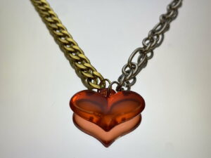 Collier et coeur plastique rouge